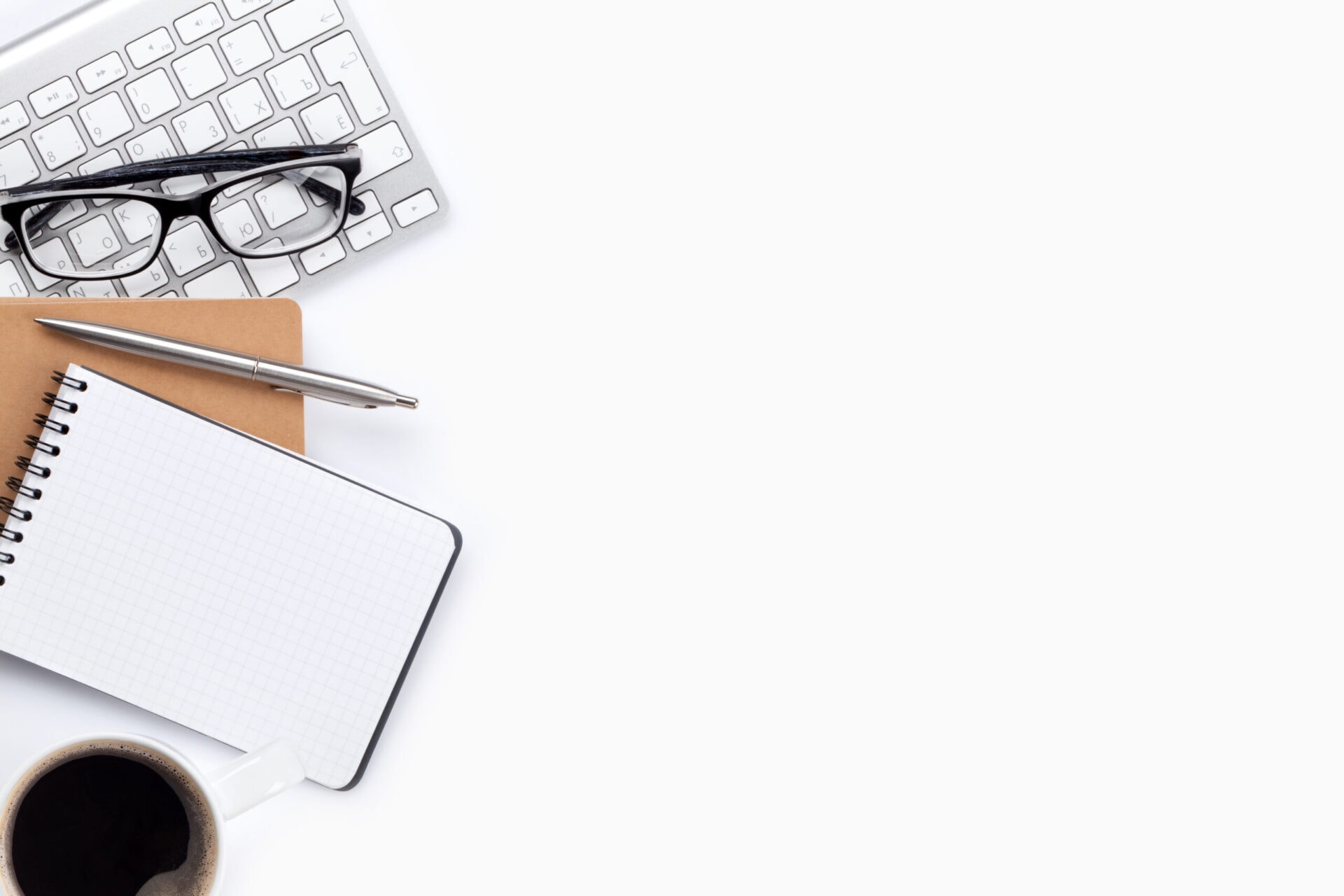 Keyboard, notepad and coffee on the desk